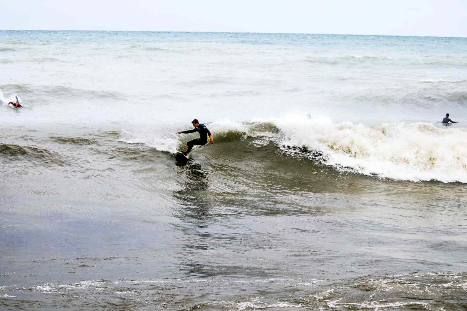 Man in a wetsuit surfs in the wintery waters of the Great Lakes