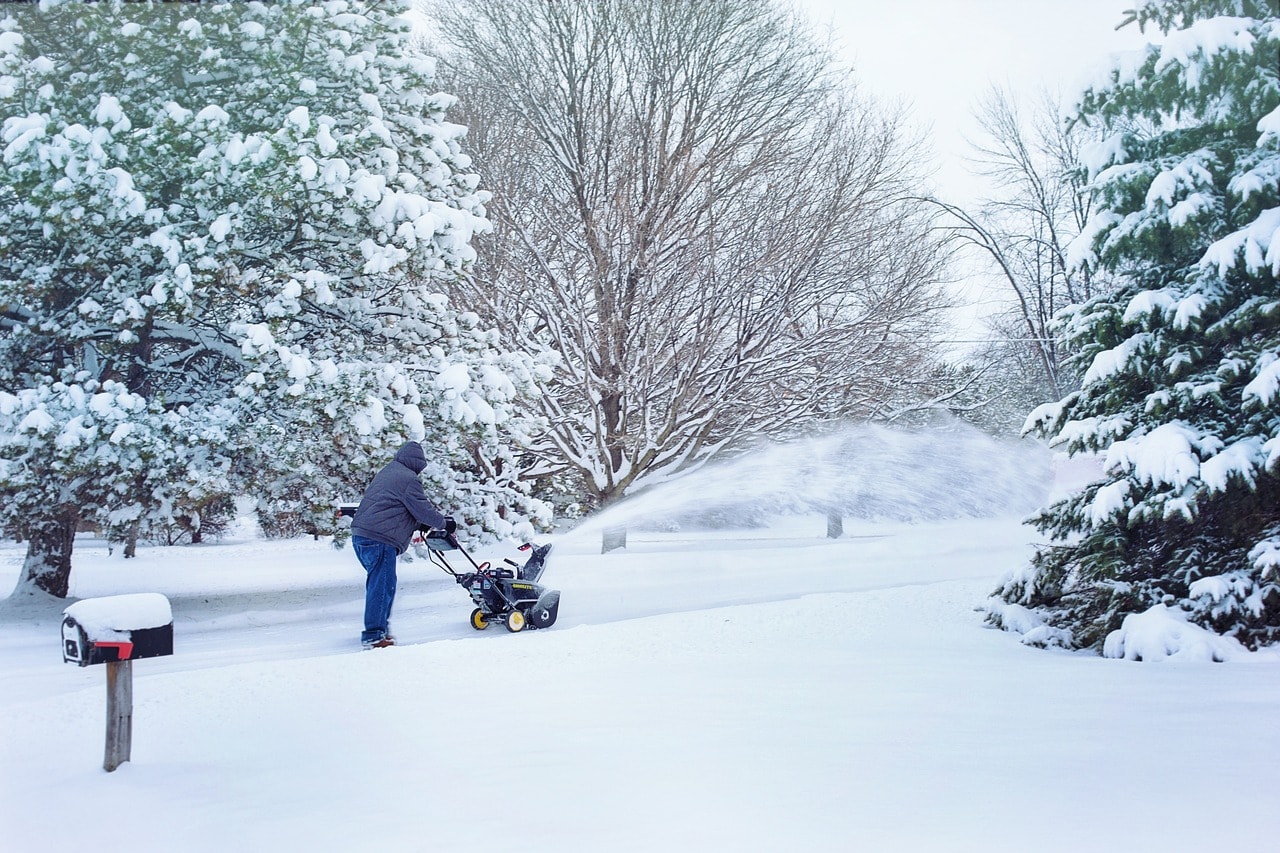A man snow blows his driveway after a fresh heavy snowfall.