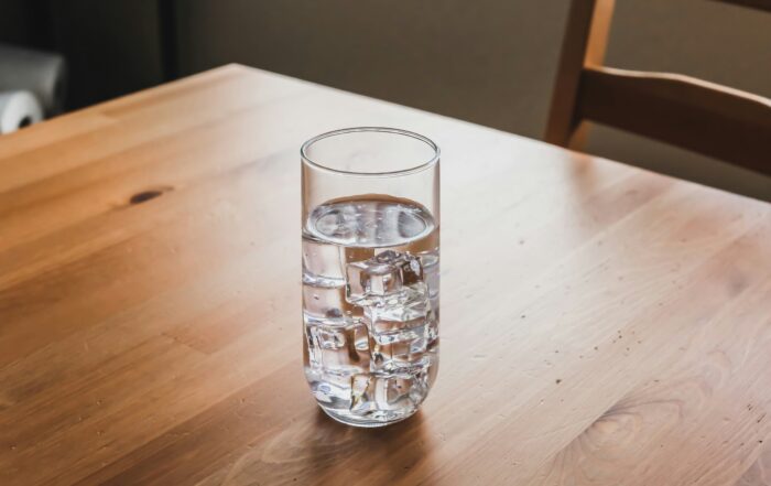 A glass of ice water sits on a table